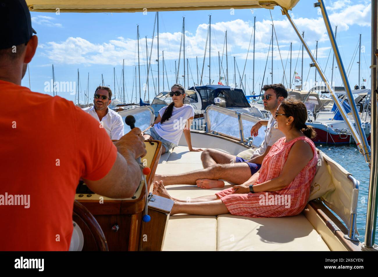 Una barca charter con turisti in partenza dal porto di Santa Maria di Leuca per le grotte lungo la riva verso il mare Adriatico. Puglia, Italia. Foto Stock