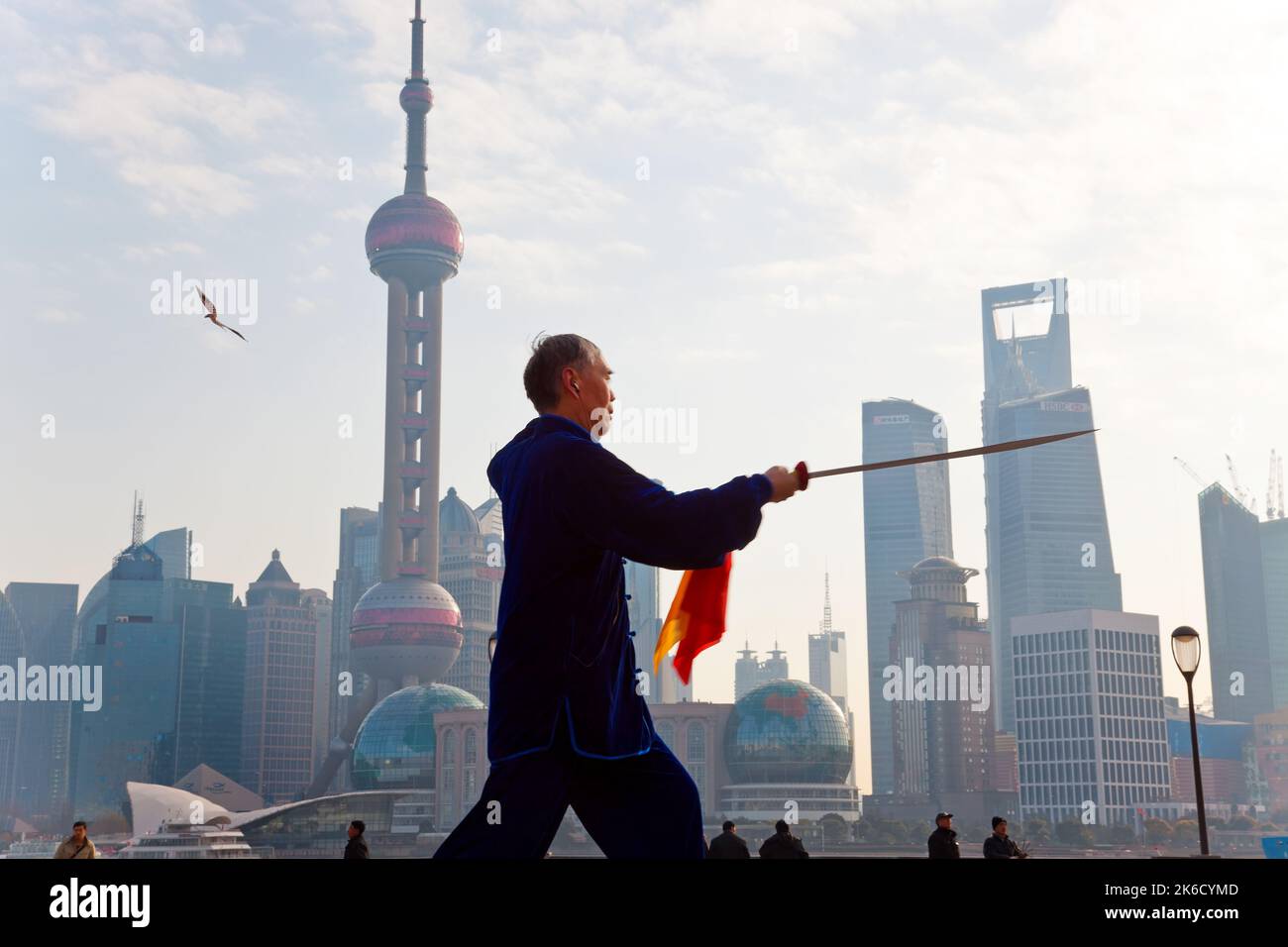 Praticare il Tai Chi con la spada, con lo skyline di Pudong, la mattina presto, Shanghai, Cina Foto Stock