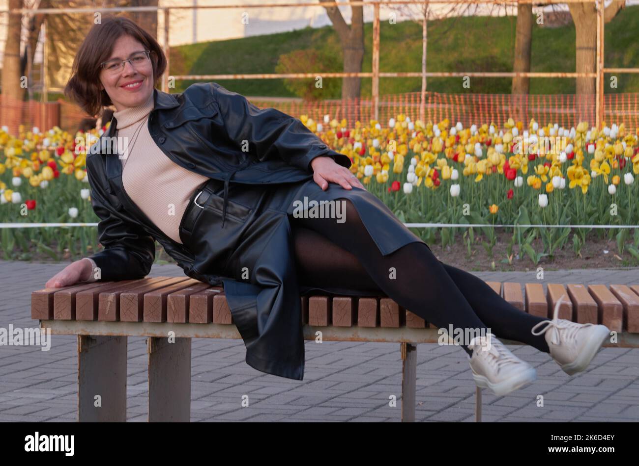 Una donna giace sul sameka sullo sfondo di un prato con tulipani Foto Stock