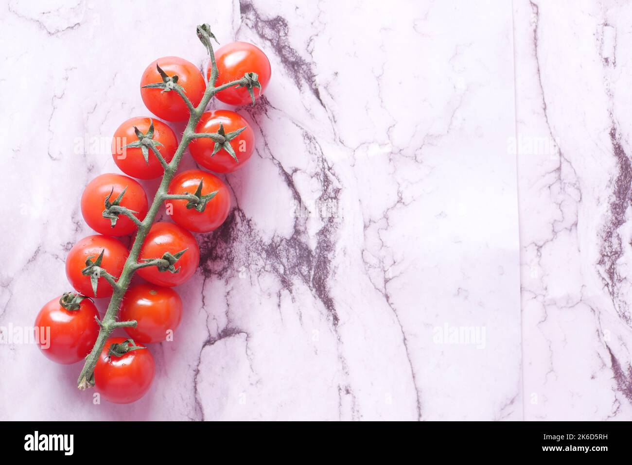 pomodoro di colore rosso su sfondo piastrelle bianche Foto Stock