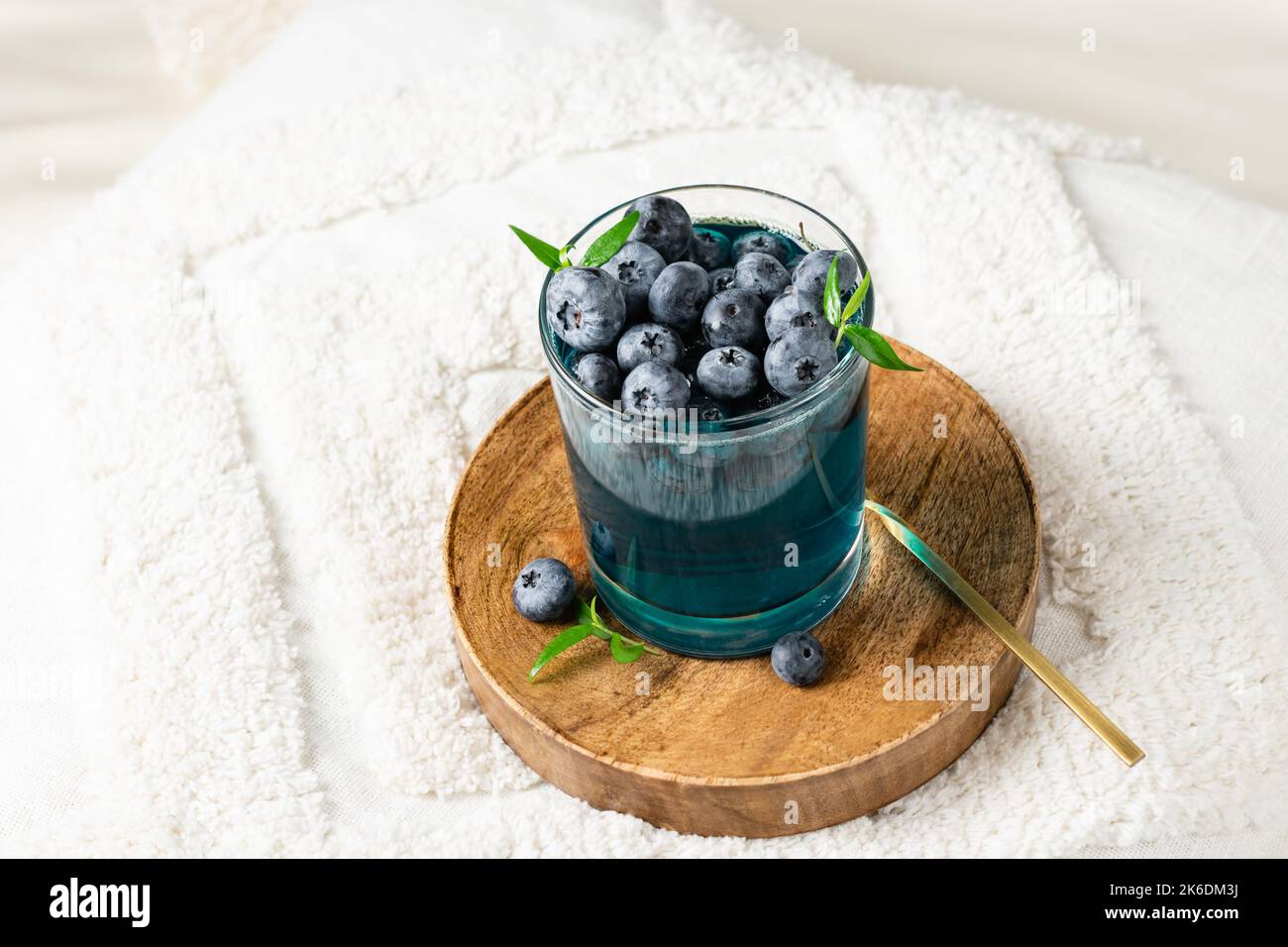 Dessert di gelatina di mirtillo in un bicchiere su un vassoio di legno Foto Stock