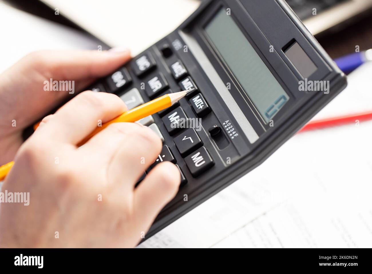 Una donna gestisce le spese familiari utilizzando il calcolatore Foto Stock