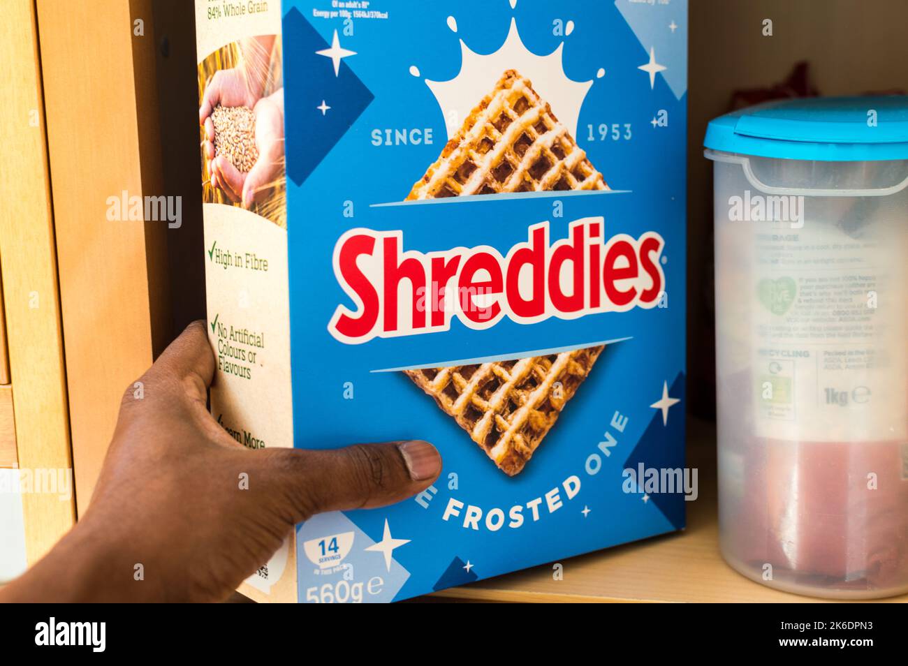 Maschio asiatico adulto che raccoglie una scatola di cereali a casa armadio cibo Foto Stock