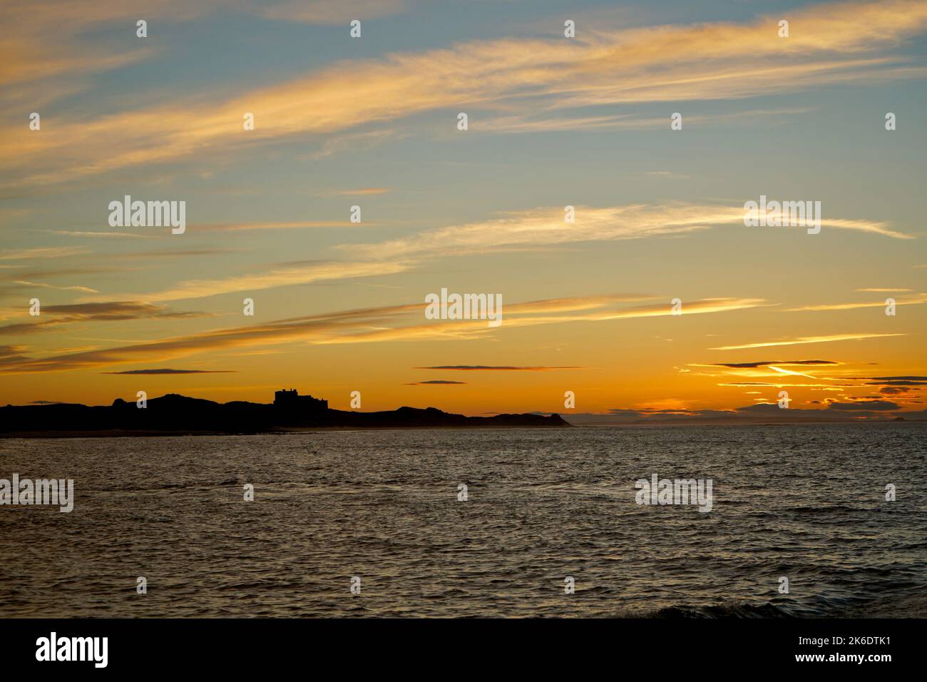 Tramonto sul mare sul Castello di Bamburgh Foto Stock