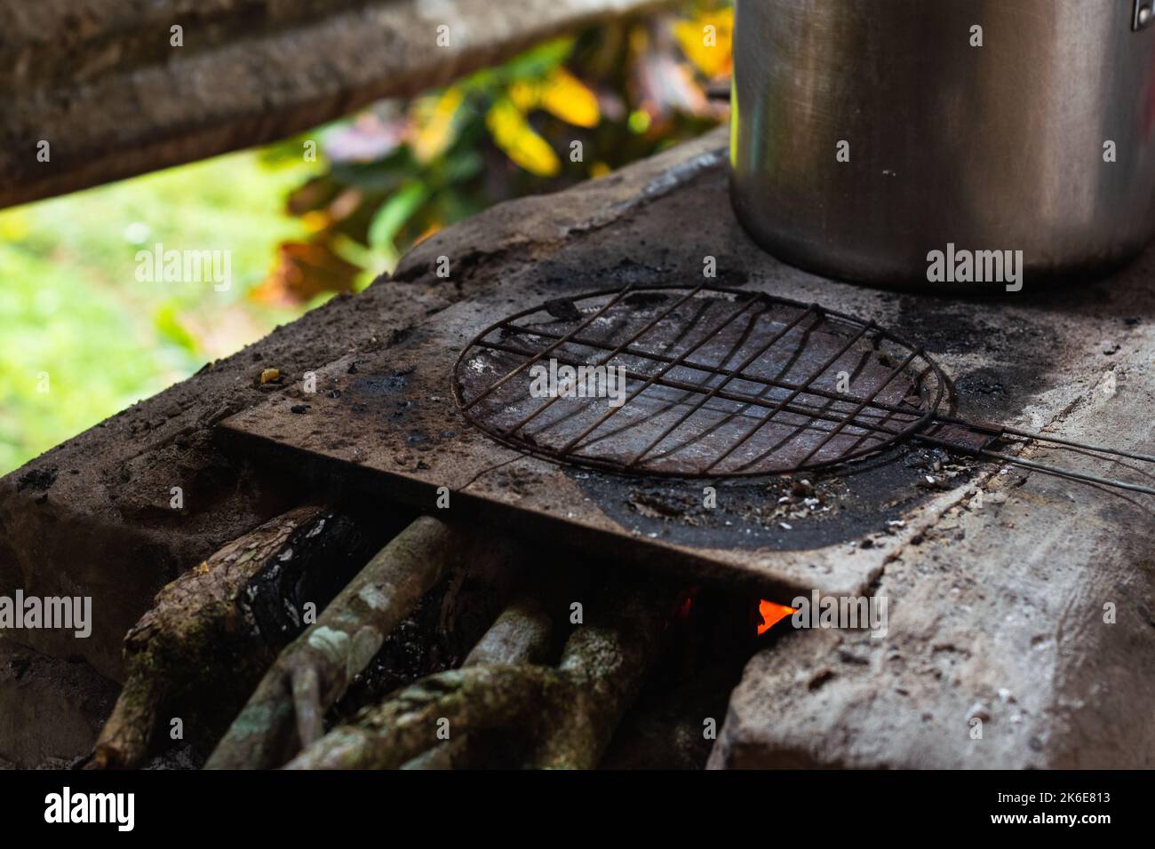 Griglia per la preparazione di arepi colombiani tradizionali in cima a una stufa fatta a mano in mattoni e cenere. Cucina tradizionale colombiana fattoria. Foto Stock