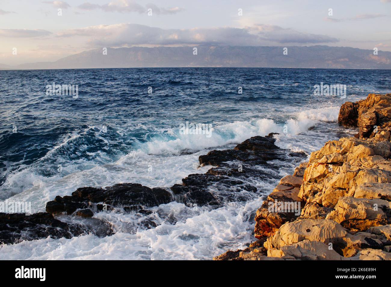 Onde di mare che colpiscono la spiaggia rocciosa Foto Stock