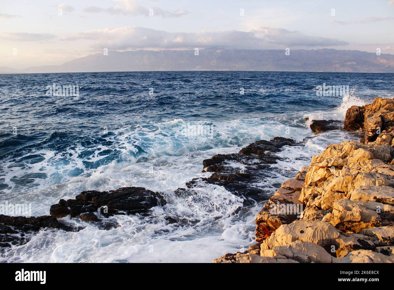 Onde di mare che colpiscono la spiaggia rocciosa Foto Stock
