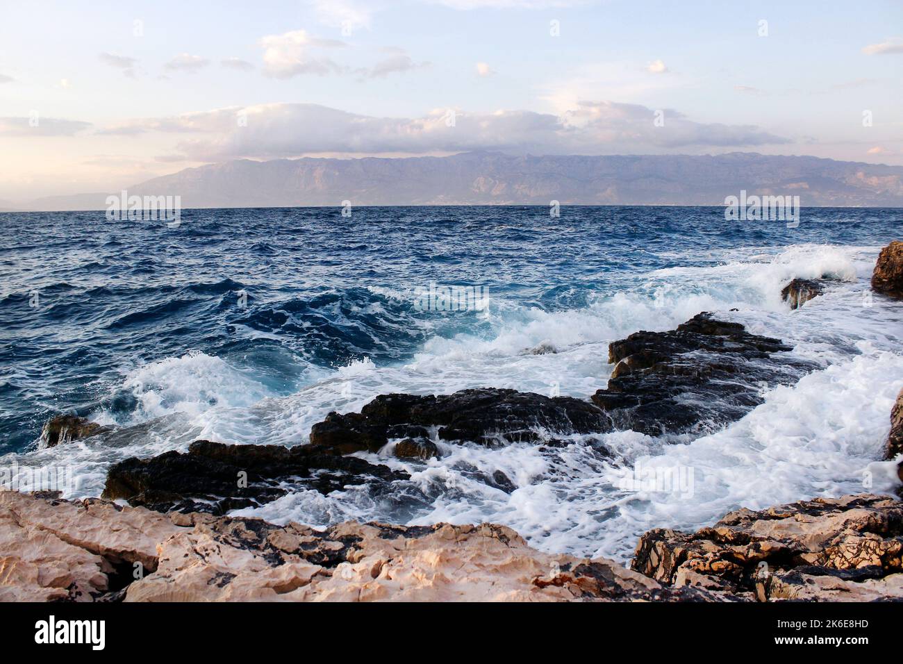 Onde di mare che colpiscono la spiaggia rocciosa Foto Stock