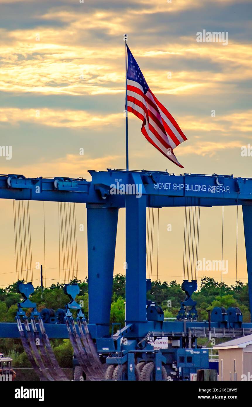 Una bandiera americana vola sopra un argano da 600 tonnellate Marine Travelift presso Signet Shipbuilding & Repair, un cantiere navale di proprietà di Signet Maritime Corporation. Foto Stock