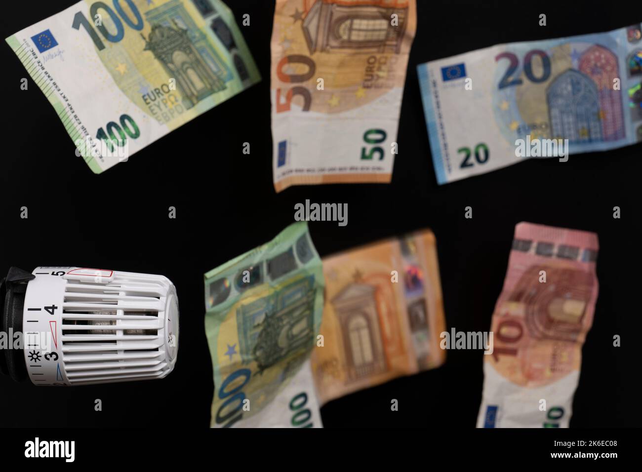 costi di riscaldamento costosi. Termostato con diverse banconote in euro in caduta Foto Stock