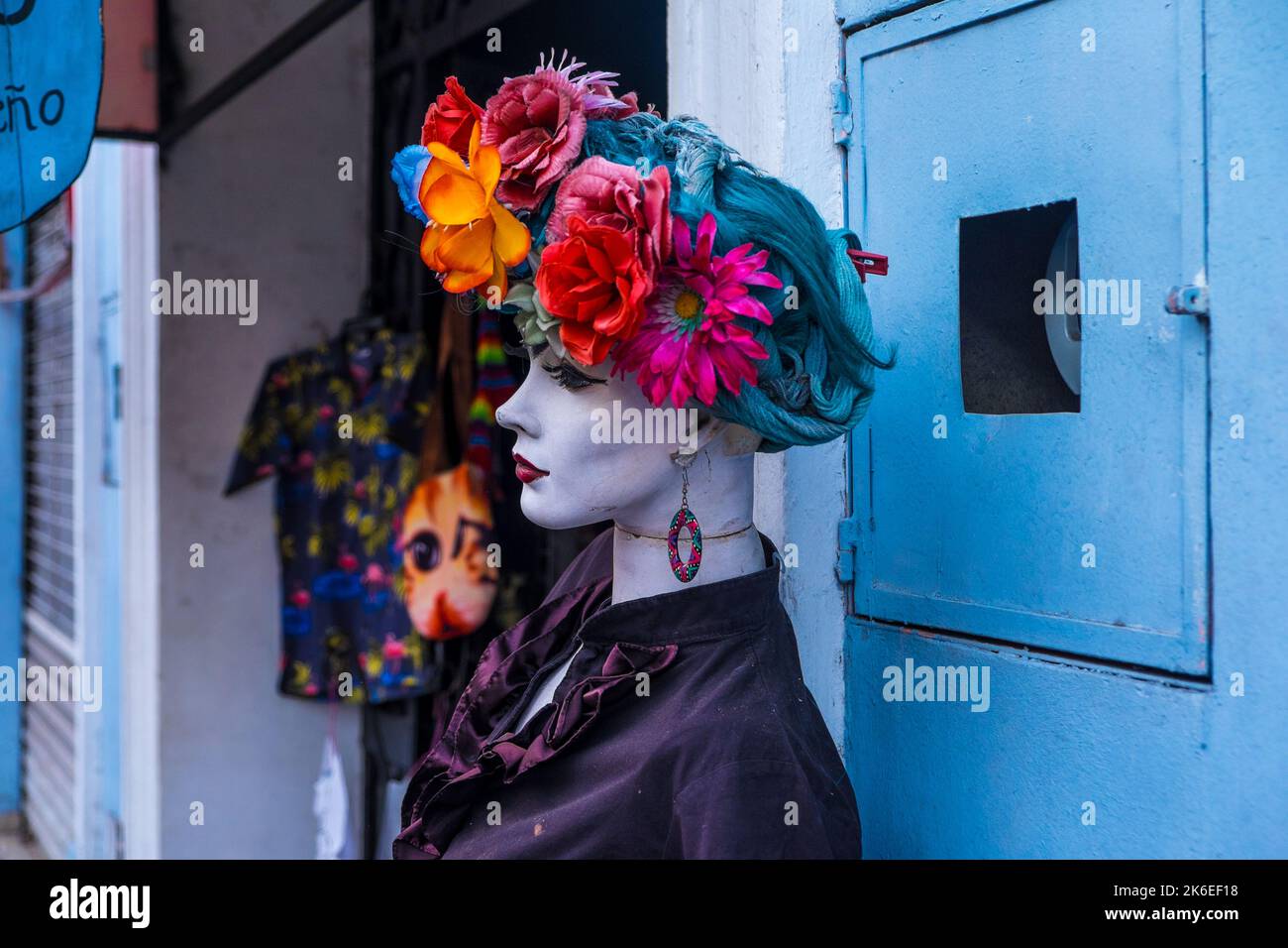Manichino con fiori colorati sulla testa fuori da un negozio Foto Stock
