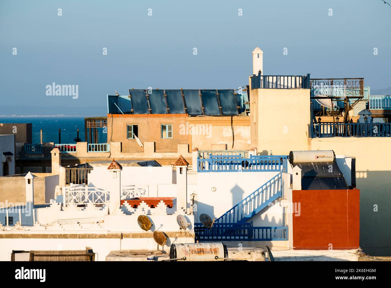 Si affaccia su terrazze densamente affollate sul tetto con la costa atlantica sullo sfondo a Essaouira, Marocco, Nord Africa Foto Stock