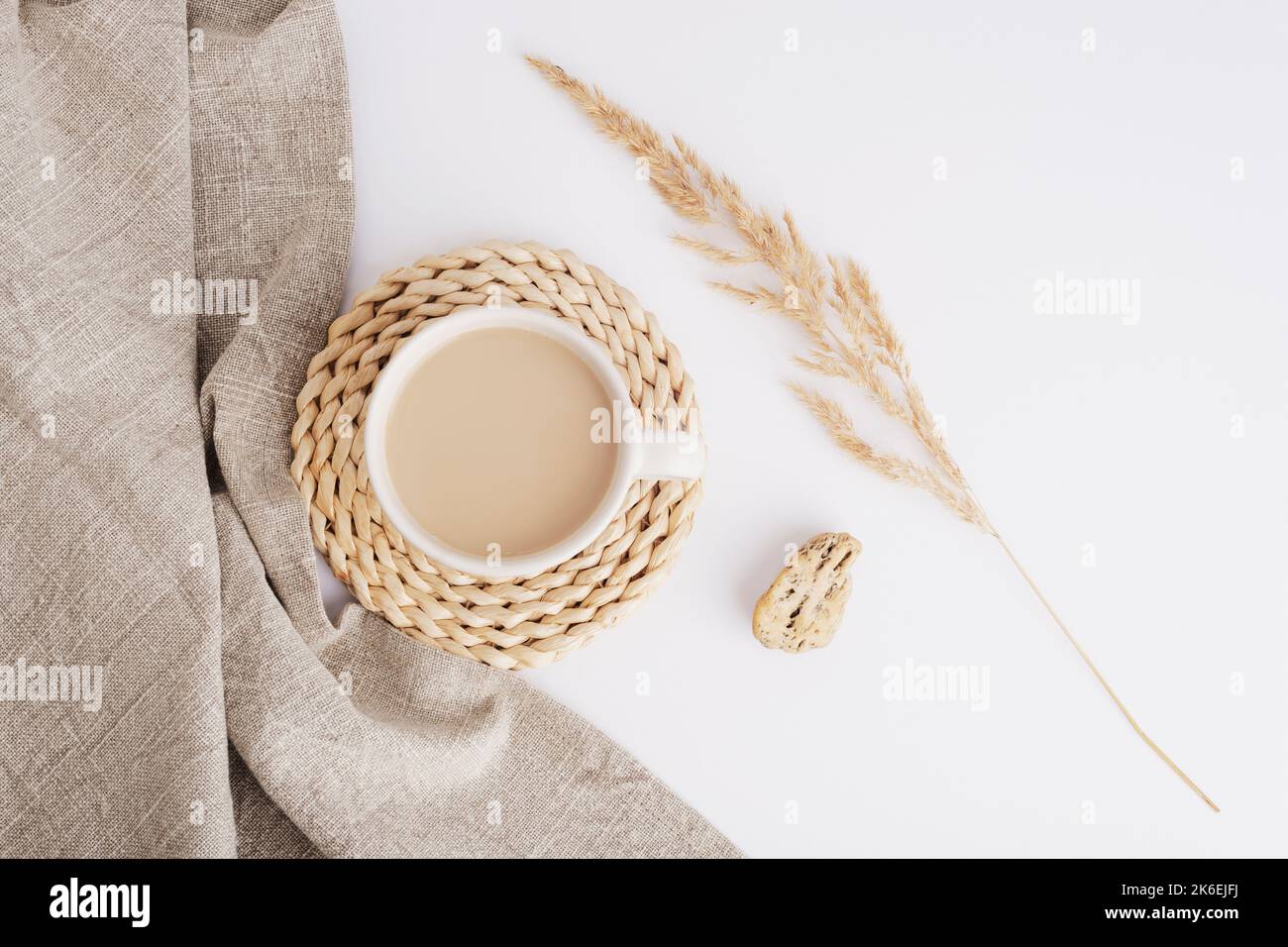 Tazza di caffè o cacao, tovagliolo di stoffa e pampas erba su sfondo bianco. Ancora vita. Vista dall'alto, disposizione piatta. Foto Stock