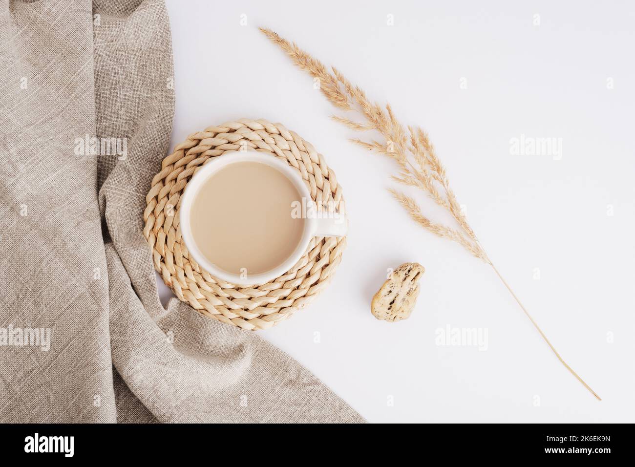 Tazza di caffè o cacao, tovagliolo di stoffa e pampas erba su sfondo bianco. Ancora vita. Vista dall'alto, disposizione piatta. Foto Stock