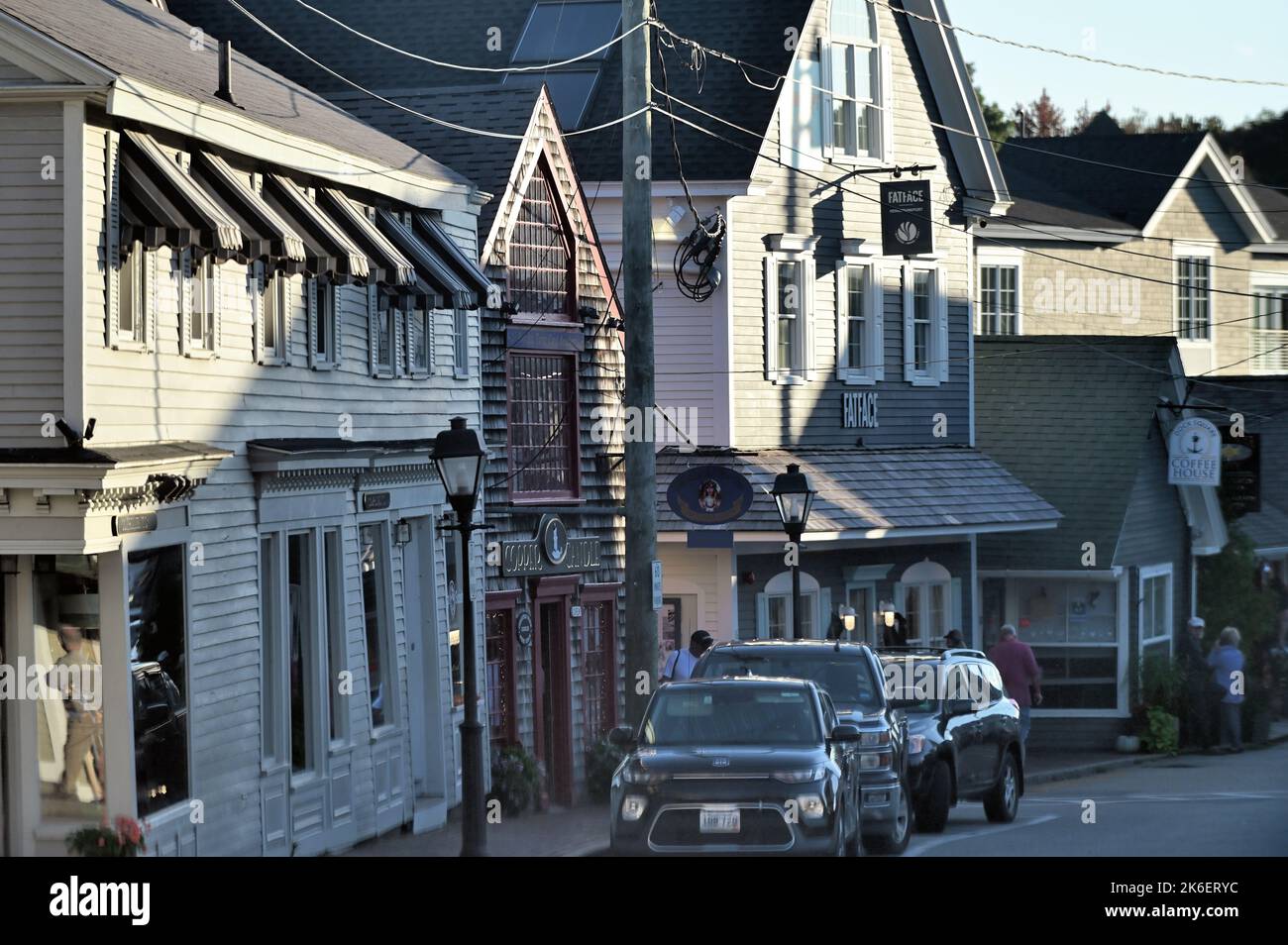 Kennebunkport, Maine, Stati Uniti. La luce tarda di una giornata autunnale mette in risalto negozi e ristoranti di lusso che punteggiano una strada principale della città. Foto Stock