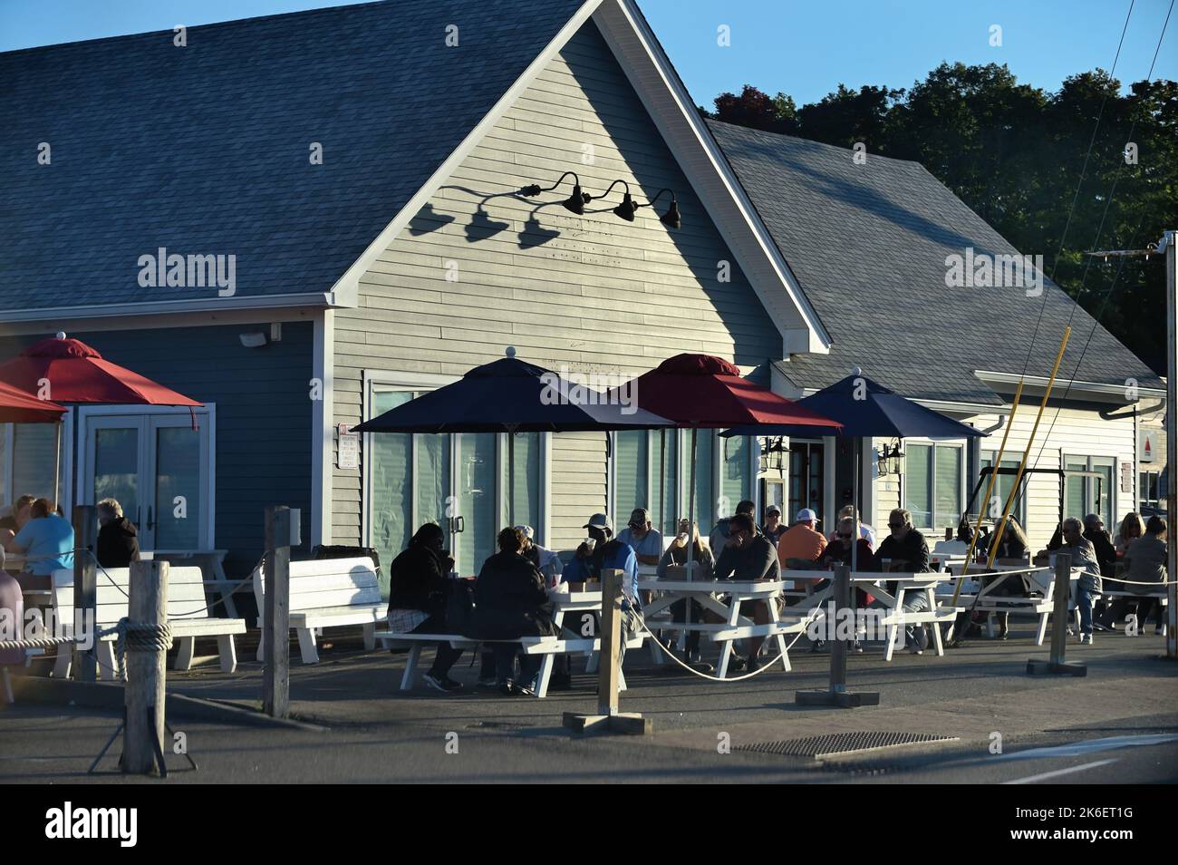 Kennebunkport, Maine, Stati Uniti. I visitatori, alla luce tarda di una giornata autunnale, potranno cenare all'aperto in un ristorante locale nell'elegante Dock Square. Foto Stock