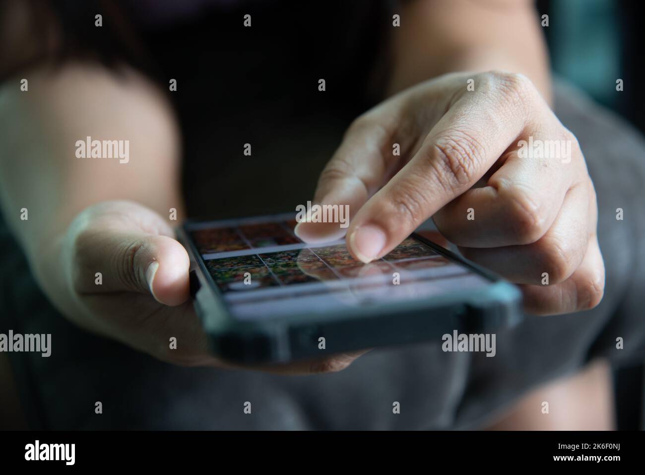 donna che sceglie le immagini sullo smartphone. Foto Stock