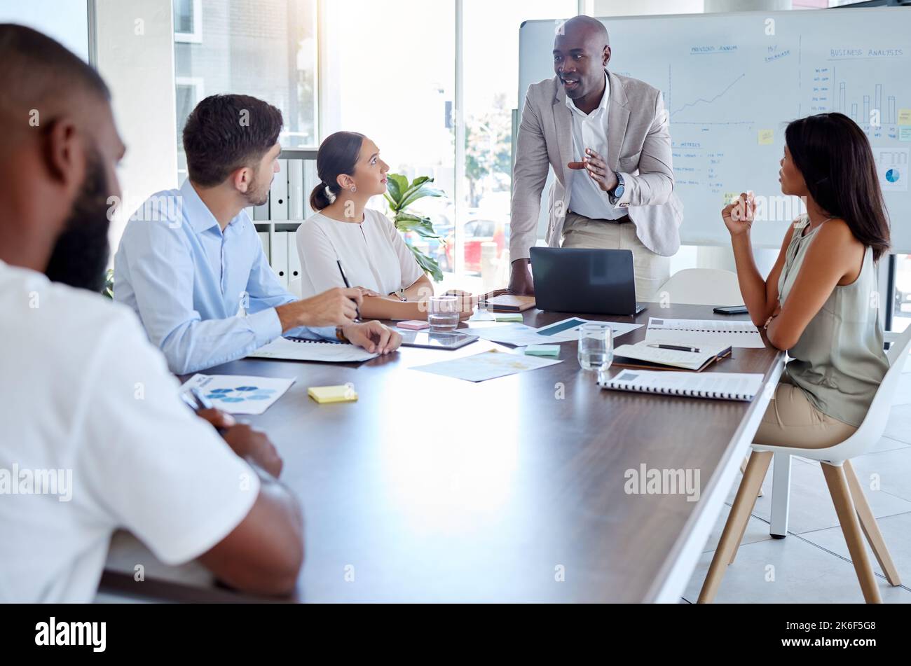 Presentazione di black man, speaker e laptop in riunioni aziendali, pianificazione strategica e sala riunioni globale per il marketing digitale. Responsabile della conversazione Foto Stock