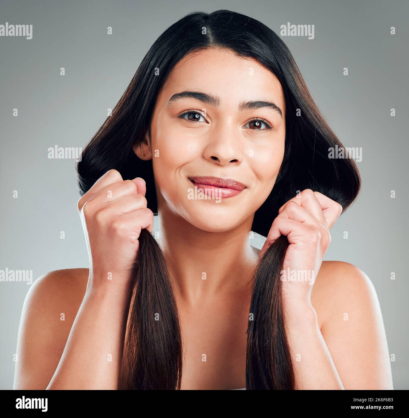 I miei capelli sono ben nutriti. Studio shot di una bella giovane donna con lunghi capelli castani. Foto Stock