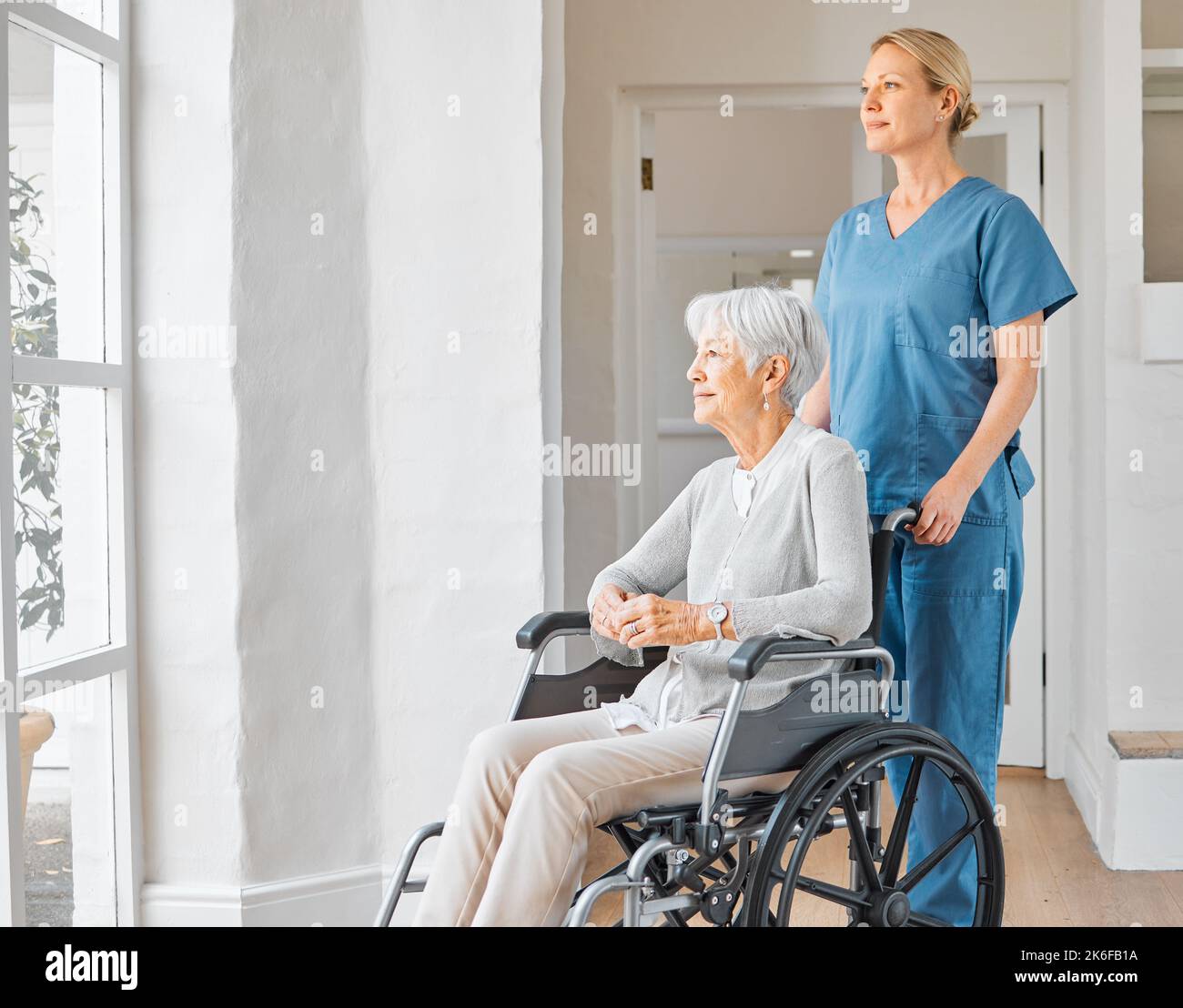 Le cose cambieranno per il meglio, lo so appena. un'infermiera che si occupa di una donna anziana su una sedia a rotelle in una casa di riposo. Foto Stock