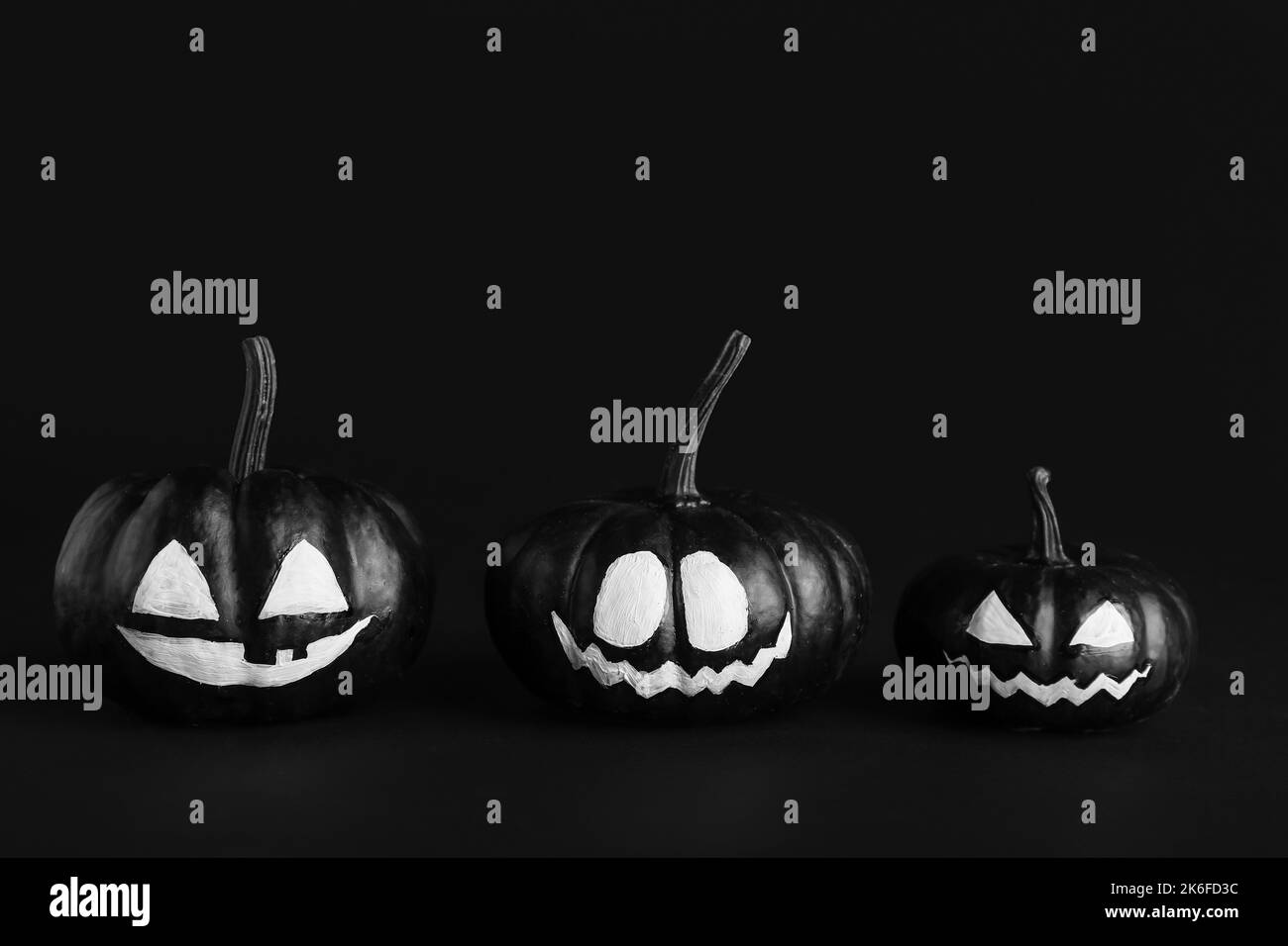 Zucche di Halloween con facce disegnate su sfondo scuro Foto Stock