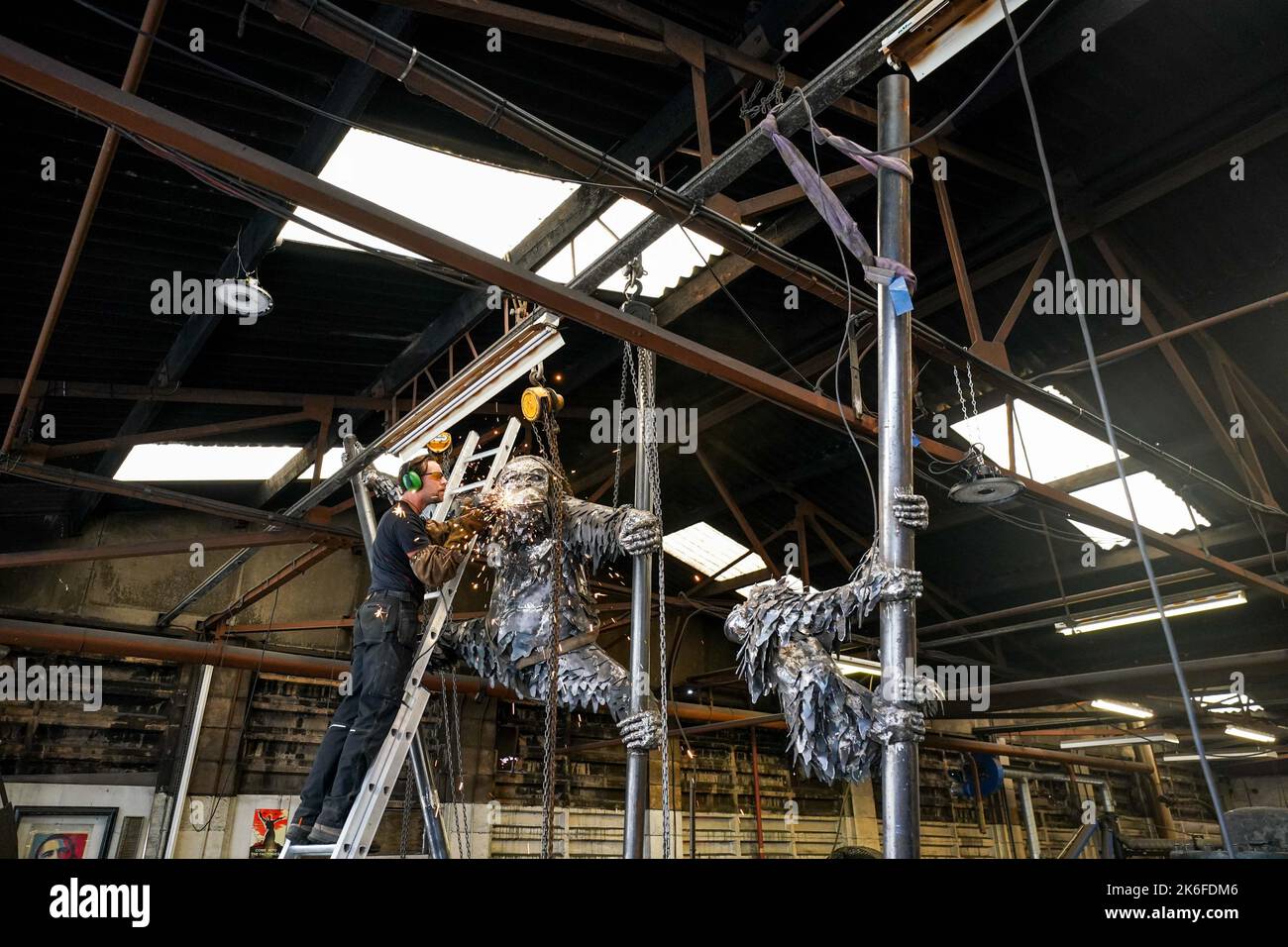 Lo scultore Luke Perry applica tocchi finali con un smerigliatore angolare alla sua ultima creazione, un'enorme statua di orangutan in acciaio per evidenziare la situazione delle specie in pericolo critico. La struttura, che misura circa 40m, sarà installata presso lo Zoo di Dudley, dove due orangutani del Borneo sono nati di recente. Perry ??? direttore della roccaforte del patrimonio industriale ??? spera che il pezzo impressionante aumenterà la consapevolezza circa la deforestazione, la produzione di olio di palma e le conseguenze per tali animali. Data immagine: Giovedì 13 ottobre 2022. Foto Stock