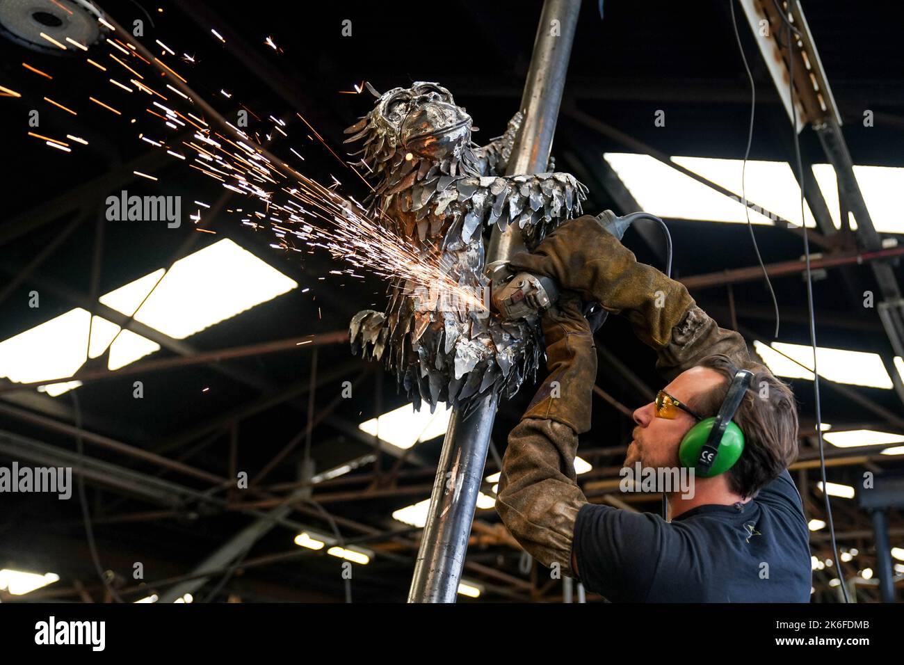 Lo scultore Luke Perry applica tocchi finali con un smerigliatore angolare alla sua ultima creazione, un'enorme statua di orangutan in acciaio per evidenziare la situazione delle specie in pericolo critico. La struttura, che misura circa 40m, sarà installata presso lo Zoo di Dudley, dove due orangutani del Borneo sono nati di recente. Perry ??? direttore della roccaforte del patrimonio industriale ??? spera che il pezzo impressionante aumenterà la consapevolezza circa la deforestazione, la produzione di olio di palma e le conseguenze per tali animali. Data immagine: Giovedì 13 ottobre 2022. Foto Stock