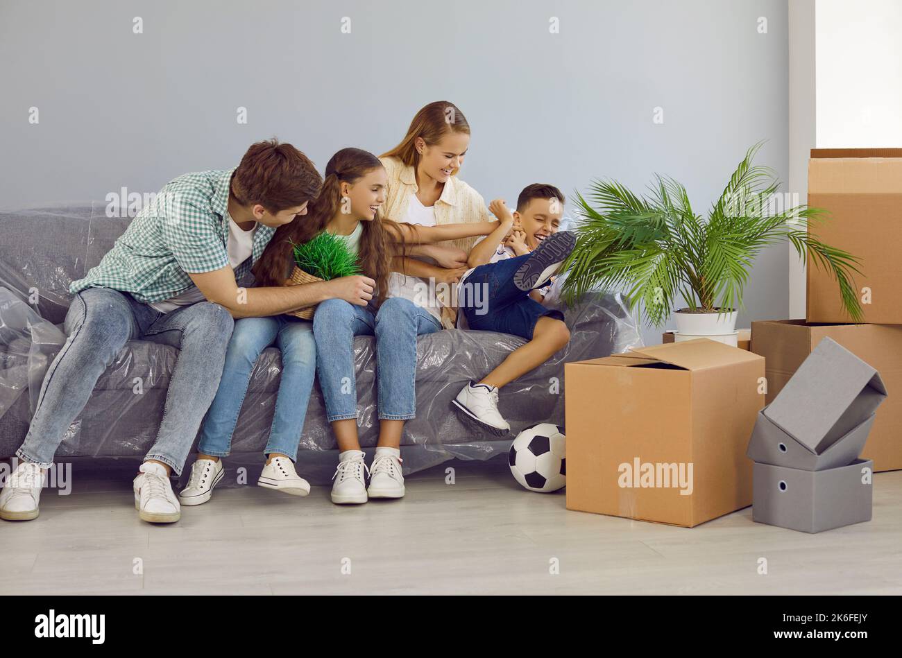 La famiglia giovane con i bambini che stanno trasferendosi alla nuova casa prenda la rottura, divertitevi e fool intorno. Foto Stock