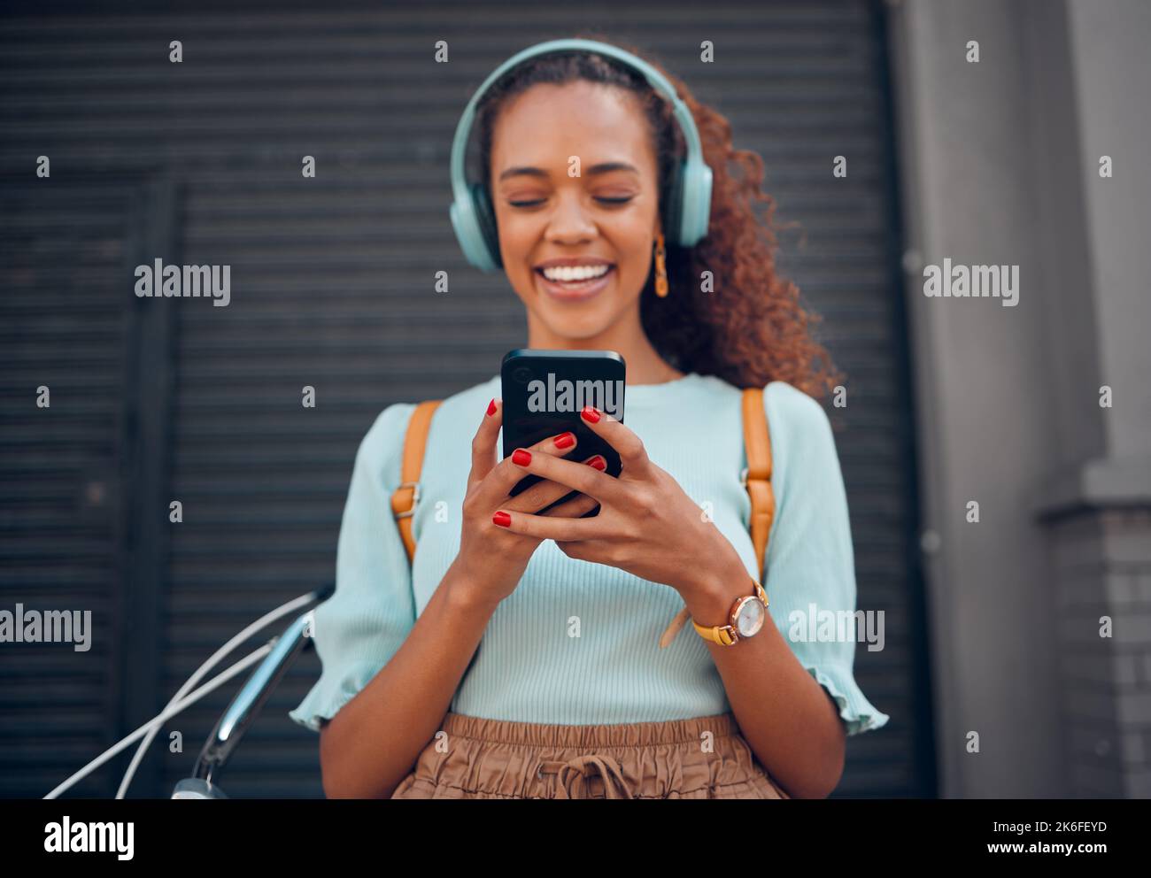 Telefono, musica e social media con una donna nera che trasmette audio in streaming tramite un servizio di abbonamento in città. Viaggio, comunicazione e SMS Foto Stock