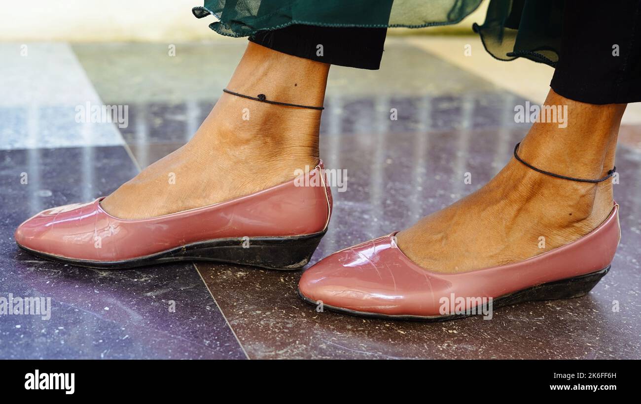 Primo piano delle gambe della donna con una scarpa in pelle che cammina nel salotto di casa. Foto Stock