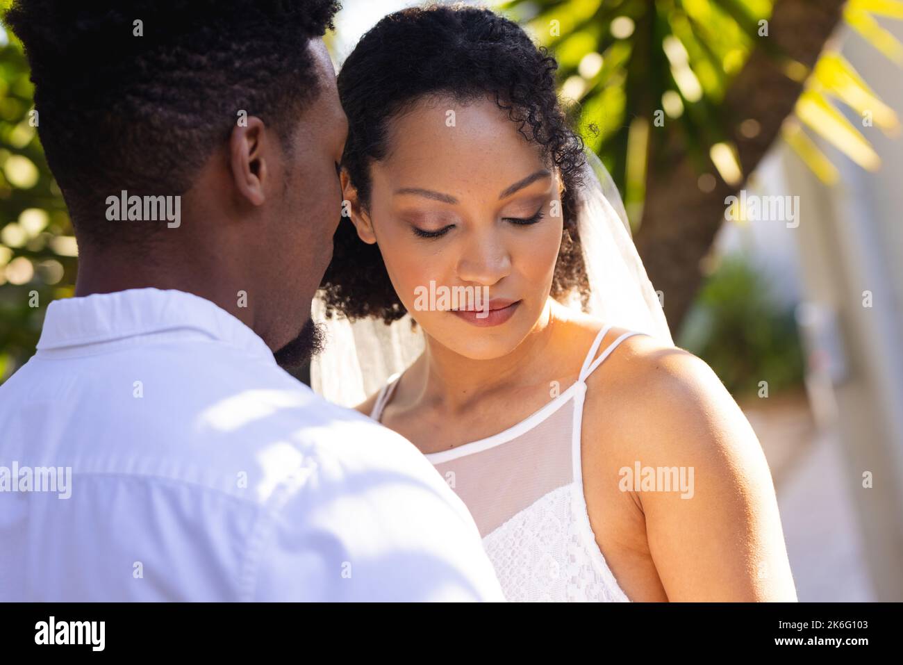 Felice coppia afroamericana sposarsi, abbracciarsi durante il giorno del matrimonio Foto Stock