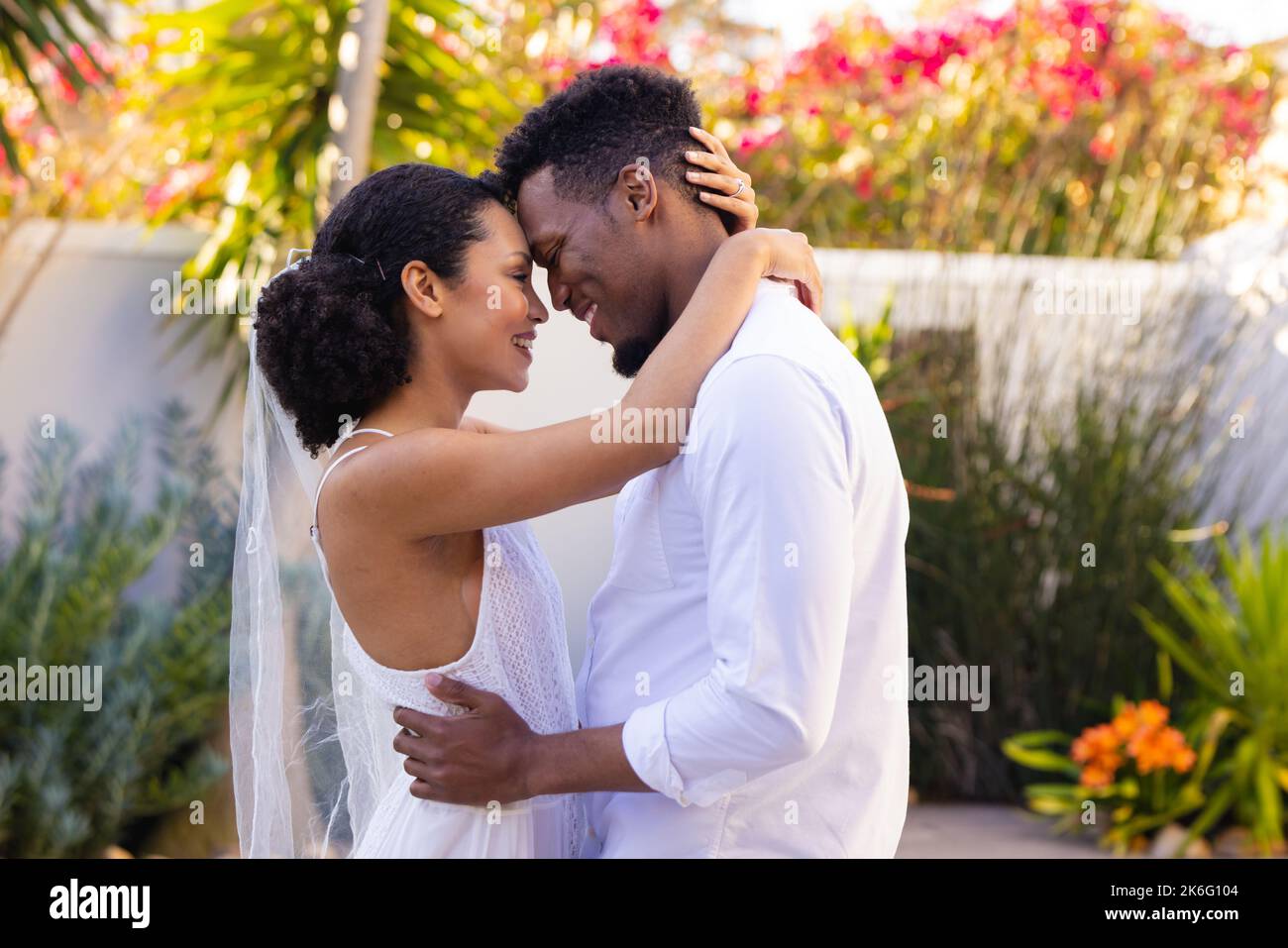 Felice coppia afroamericana sposarsi, abbracciarsi durante il giorno del matrimonio Foto Stock