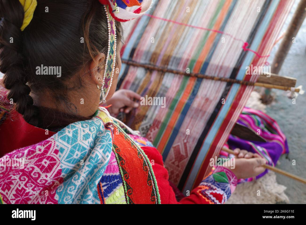 Cusco, Perù - 1 luglio, 2022: Una signora di Quechua tesse tessuti andini tradizionali utilizzando lana alpaca Foto Stock