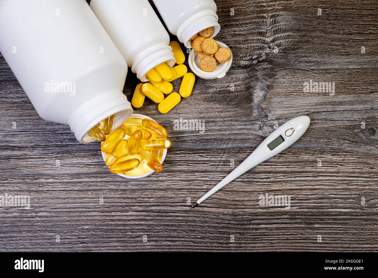 Top view mockup bottiglia per pillole e vitamine su sfondo nero, naturale bio supplemento biologico Pillole mediche in vaso bianco su un isolato ba di legno Foto Stock