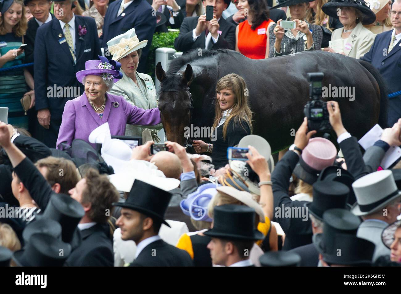 Ascot, Berkshire, Regno Unito. 20th giugno, 2013. Sua Maestà la Regina e sua figlia Principessa Anna hanno una foto con la stima del cavallo vincente della Regina. Questa era una giornata storica in quanto era la prima volta che un monarca regnante aveva vinto la Gold Cup. La stima è stata guidata dal jockey Ryan Moore. La regina Elisabetta II era dovuta alla presentazione per la Coppa d'Oro, ma suo figlio, il Duca di York, fece la presentazione. Data di pubblicazione: 14th ottobre 2022. Credito: Maureen McLean/Alamy Foto Stock