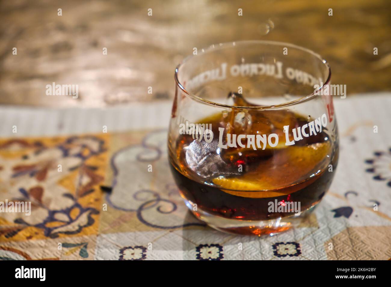 Primo piano di un bicchiere di Amaro Lucano con un pidocco di limone, un famoso liquore del sud d'Italia Foto Stock