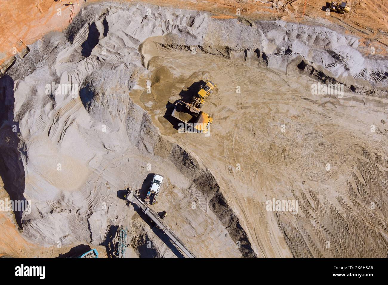 Attrezzatura di frantumazione di pietre panoramiche sul nastro trasportatore meccanico per polverizzare pietre da roccia per la produzione di ghiaia Foto Stock