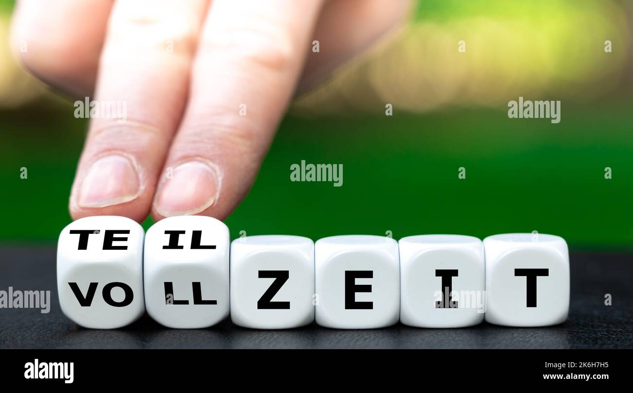 La mano gira i dadi e cambia l'espressione tedesca 'vollzeit' (a tempo pieno) in 'teilzeit' (a tempo parziale). Foto Stock