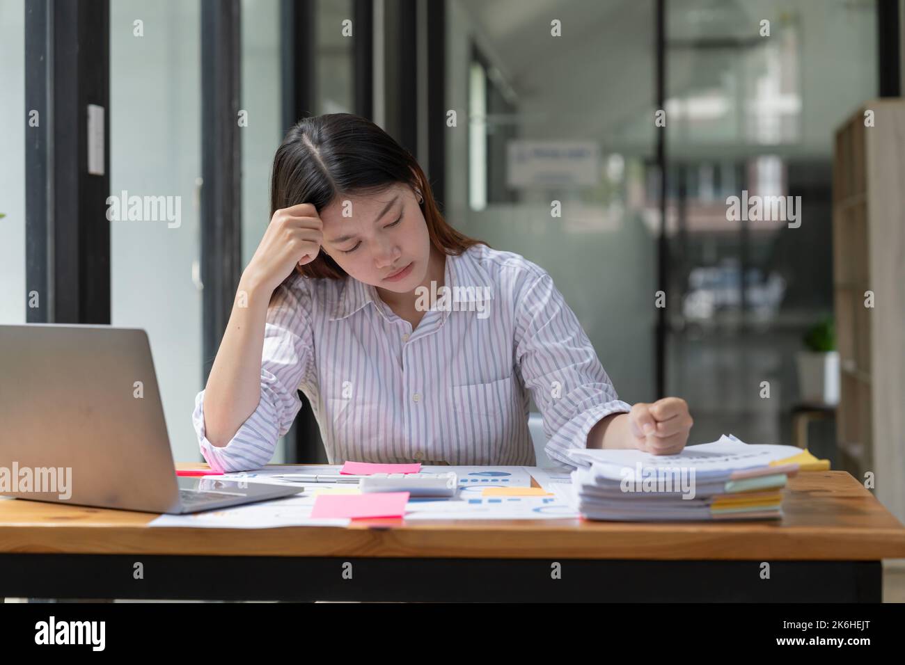 Donna asiatica che lavora duro con grave stress e mal di testa, mentre ha un problema al lavoro in officee, donna che lavora duro concetto. Foto Stock