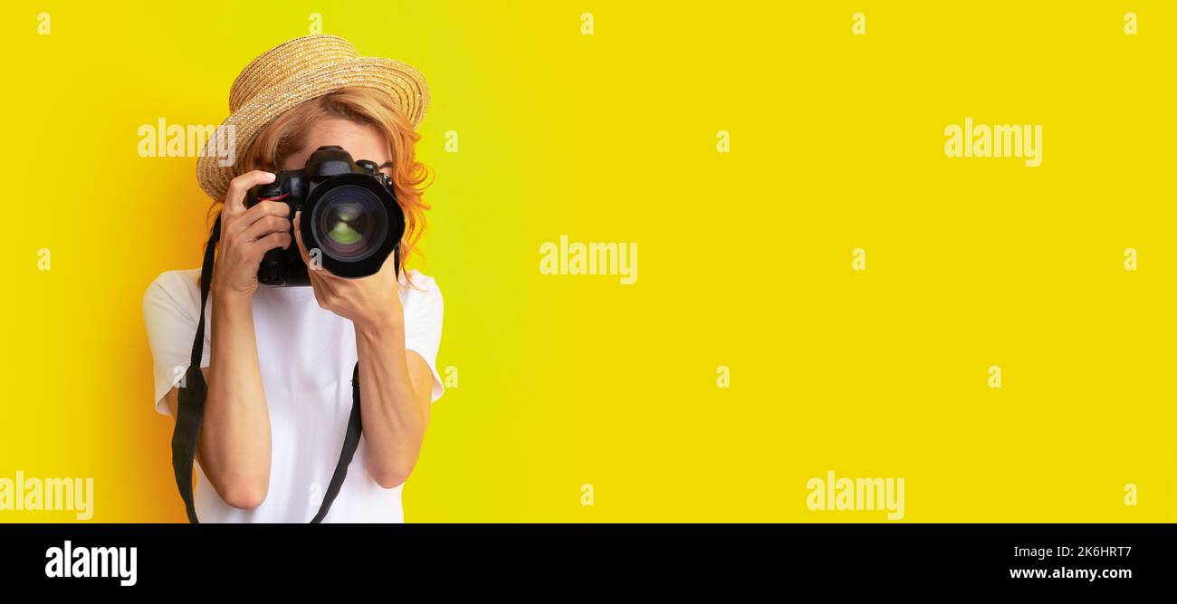 donna fotografo con macchina fotografica in cappello di paglia fare foto, obiettivo. Donna isolato volto ritratto, banner con mock up spazio copia. Foto Stock
