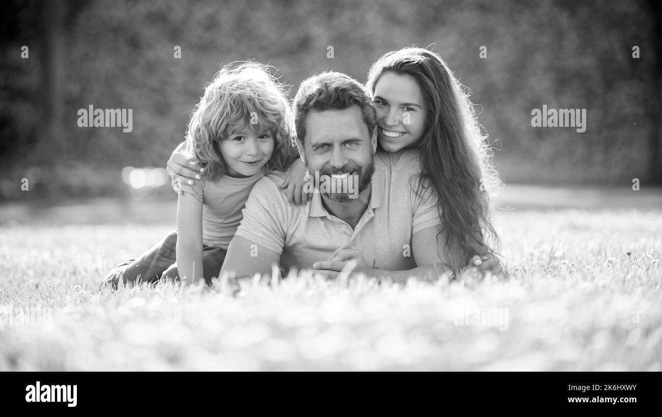 adozione e carità. giornata di famiglia. amicizia. padre madre e bambino su erba verde del parco. Foto Stock