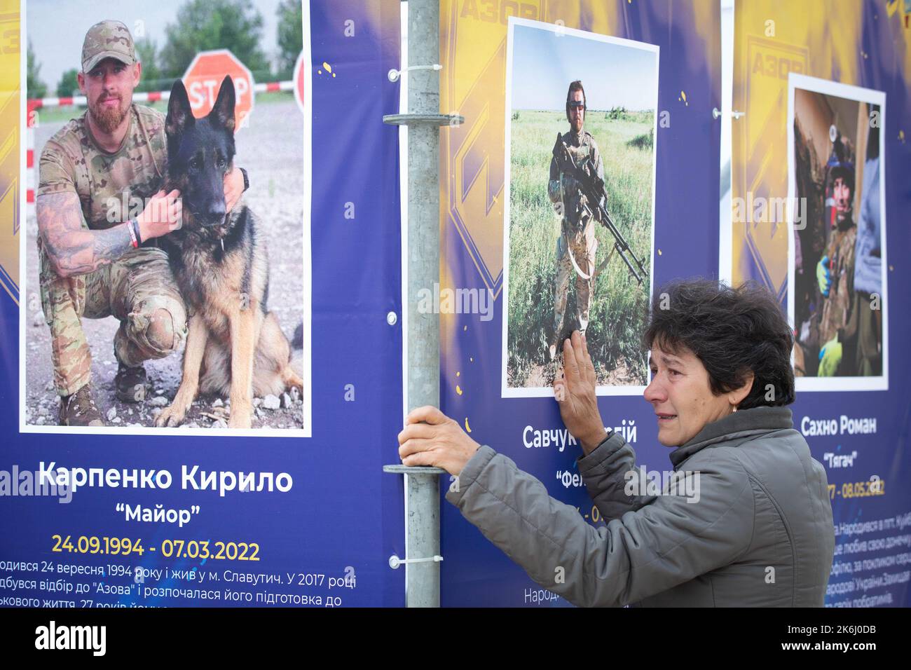 Una donna reagisce emotivamente alla mostra di strada 'Azov Regiment - Angels of Mariupol', dedicata ai difensori dell'unità 'Azov' della Guardia Nazionale Ucraina, che morì difendendo Mariupol dagli invasori russi a Kyiv. Le truppe russe sono entrate in Ucraina il 24 febbraio 2022 iniziando un conflitto che ha provocato distruzione e crisi umanitaria. Foto Stock