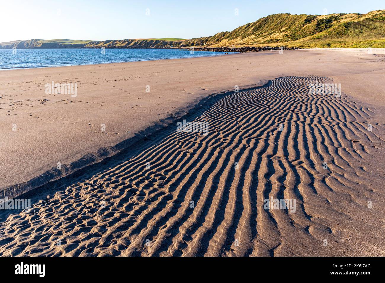 Luce serale sui motivi nella sabbia di Ardwell Bay, Dumfries & Galloway, Scozia UK Foto Stock