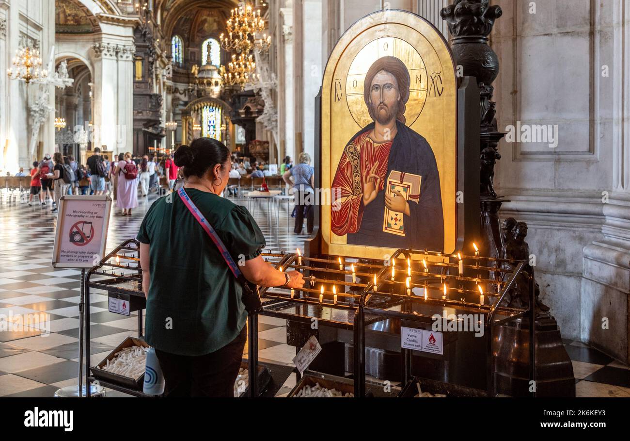 Donna illuminazione candele in di St.. Cattedrale di Pauls Londra Foto Stock
