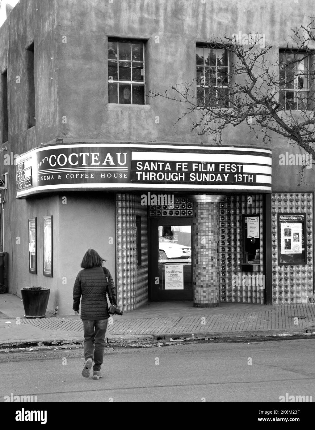 Una donna cammina verso il Jean Cocteau Cinema a Santa Fe, New Mexico. Lo storico cinema è di proprietà dell'autore americano George R.R. Martin. Foto Stock