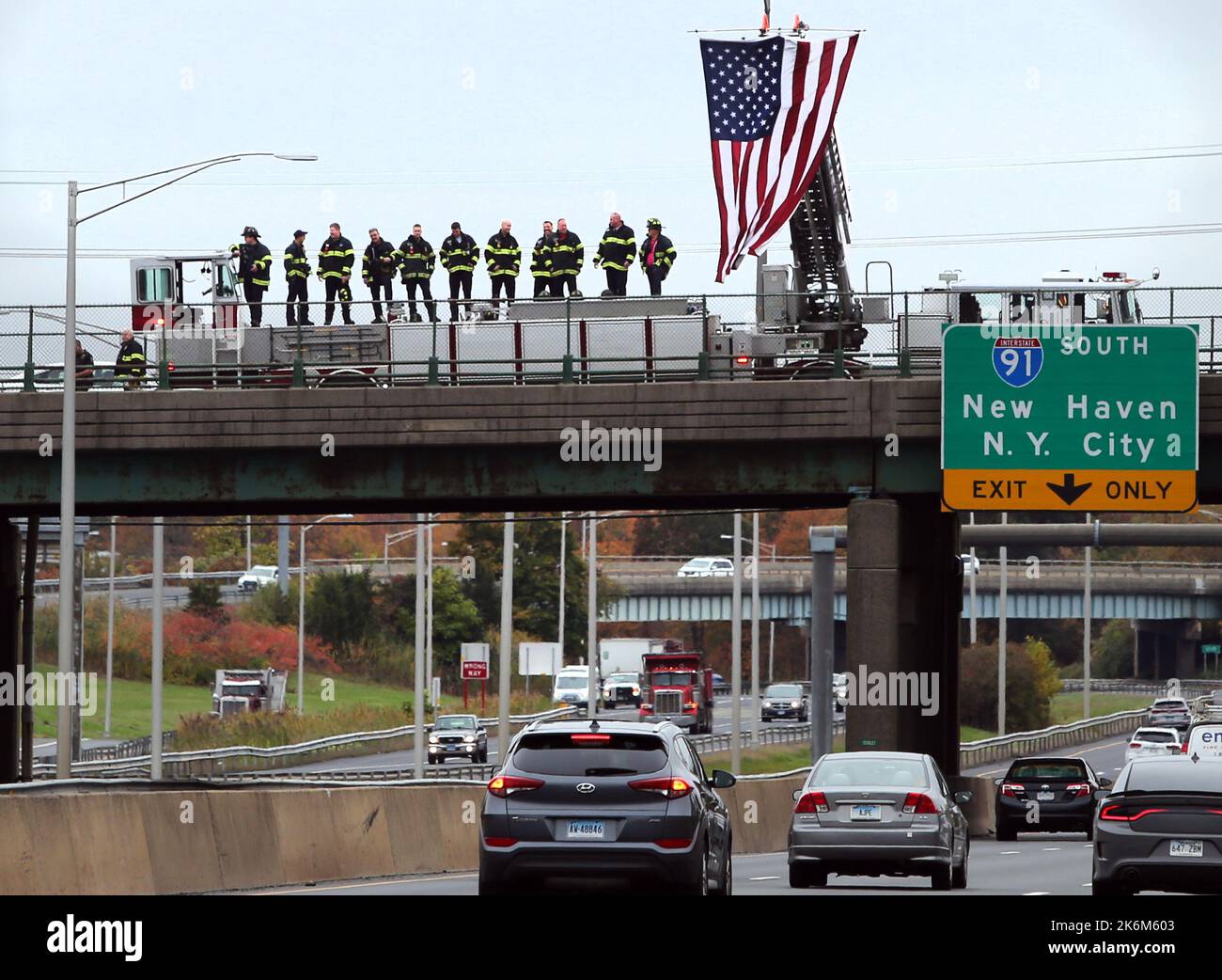 Meriden, Connecticut, Stati Uniti. 14th Ott 2022. I membri del Dipartimento dei vigili del fuoco di Meriden stanno a veglia su un cavalcavia sopra la i-91 a Meriden, Connecticut, a sostegno degli ufficiali di polizia caduti di Bristol. La sera del 12 ottobre, tre poliziotti di Bristol arrivarono a quello che pensavano fosse una disputa domestica. Sono stati incontrati da un uomo con una pistola che ha aperto il fuoco in ciò che i funzionari stanno descrivendo come un agguato. (Credit Image: © Stan Godlewski/ZUMA Press Wire) Foto Stock