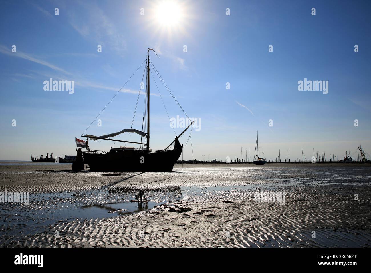 Una classica barca a vela adagiata sulle maree del Mare di Wadden, Olanda Foto Stock