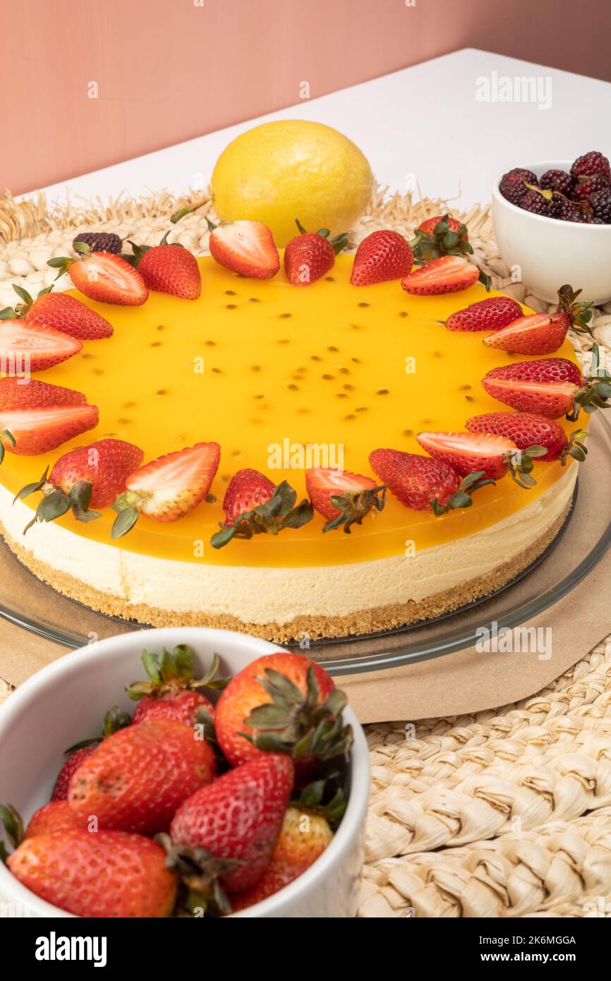 dessert in studio, cheesecake frutto della passione con crema e fragole come decorazione, cibo dolce e stile gourmet, tavolo servito Foto Stock
