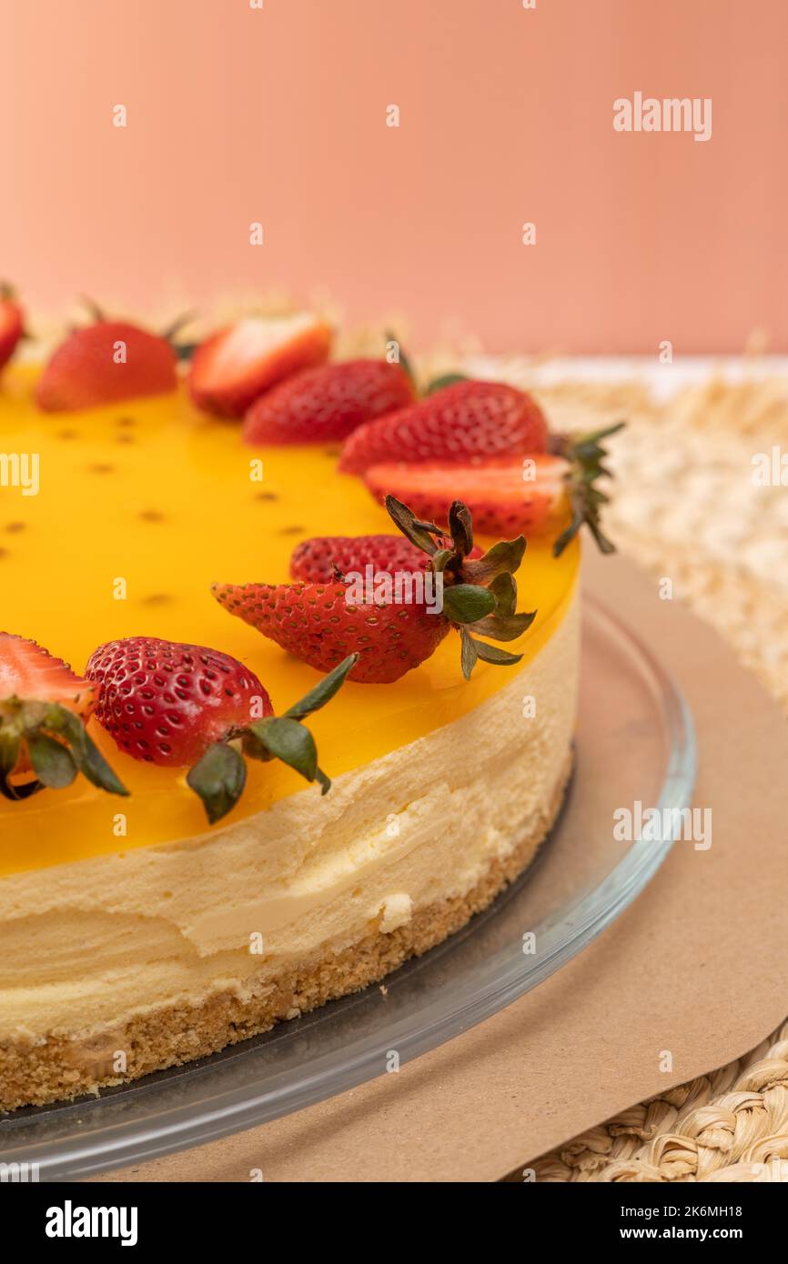 dessert con cheesecake al frutto della passione decorato con fragole, piatti dolci in stile gourmet, appetitose voglie Foto Stock