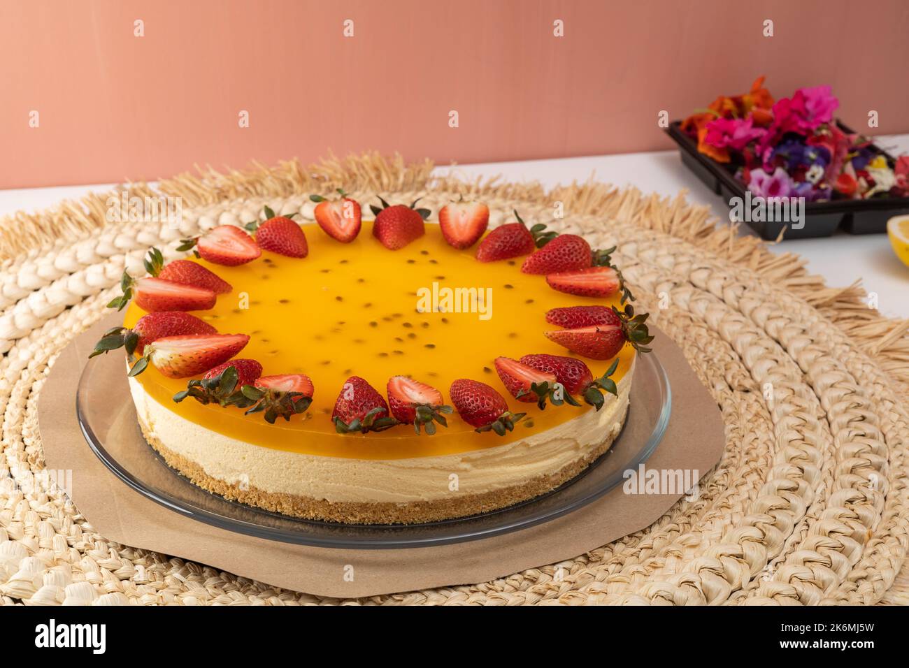 dessert per la celebrazione del compleanno, torta di forma circolare decorata con fragole, cibo con frutta tropicale in studio, carta da parati Foto Stock